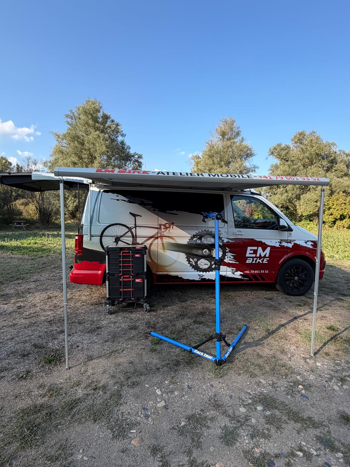 Le bus EM Bike avec son auvent, son pied d'atelier et ses caisses à outils